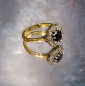 An 18ct gold sapphire & diamond cluster ring, the central oval sapphire meas. 6 x 5mm within a