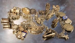 A silver charm bracelet, eleven charms including a church enclosing a bride & groom & vicar,