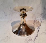 A silver low candlestick, flared sconce, knopped column, spreading base, hammered overall, 9.5cm