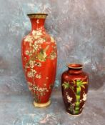 A Japanese cloisonne ovoid vase, decorated with bamboo and blossoming prunus branches, on a red
