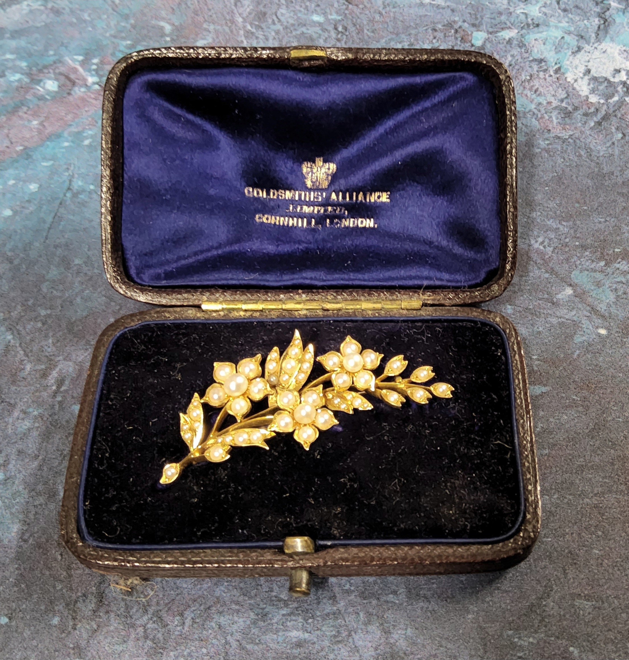 A yellow metal & seed pearl brooch in the form of a flowering branch, 7.58g in original fitted