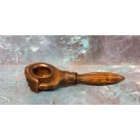 A 19th century novelty treen nut cracker, in the form of a hand clsping a nut, 19cm long