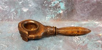 A 19th century novelty treen nut cracker, in the form of a hand clsping a nut, 19cm long