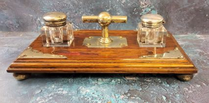 A late 19th century E.P.N.S. and oak standish, with two wells, pen apertures, 30cm wide, c.1880