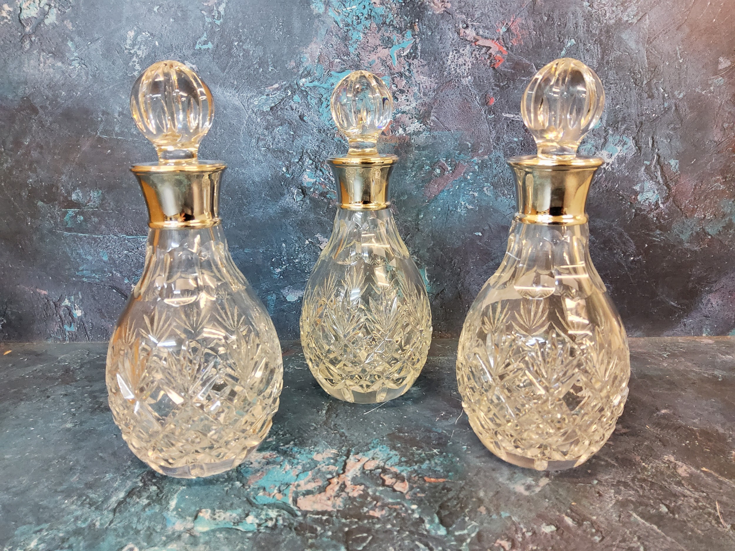 A set of three silver mounted  decanters, globular stoppers, 21cm high,  James Dixon & Sons,