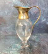 A pedestal clear glass claret jug, silver collar, spout and scroll handle, 29cm high, James Dixon