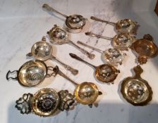 An E.P.N.S. Kings pattern tea strainer and stand;  other strainers, various;  lemon strainers;
