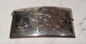 A George V silver bowed rectangular card case, engraved and chased with scrolling foliage, 8.5cm