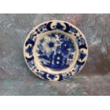 An 18th century Dutch Delft plate, decorated in underglazed blue with stylised flowers and fence,