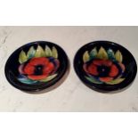 A pair of Moorcroft Pansy pattern circular plates, tubed lined with large flowerhead, on a cobalt