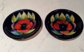 A pair of Moorcroft Pansy pattern circular plates, tubed lined with large flowerhead, on a cobalt