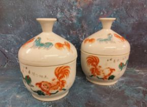 A pair of Chinese Rouge De Fer bowls and covers, decorated in the typical palette with Dogs of Fo,