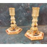 A pair of 19th century Meissen candlesticks, decorated in blue red and green, hexagonal sconces