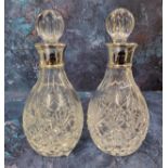 A pair of silver collared cut glass small decanters, sphere shaped cut glass stopper, James