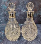 A pair of silver collared cut glass small decanters, sphere shaped cut glass stopper, James