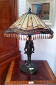 A Tiffany style lamp, beaded frill, bronzed leaf wrapped column and base