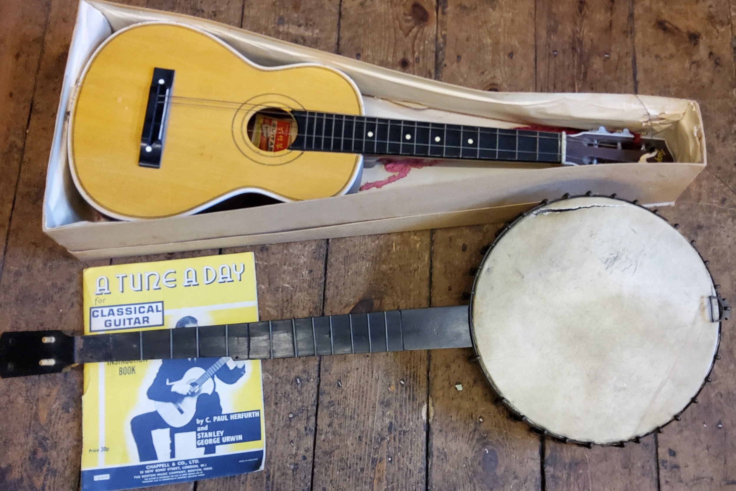 A four-string banjo; Kapok Brand guitar shaped ukulele (2)