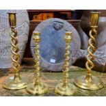 A pair of 19th century open twist brass candlesticks, another pair twisted, the largest pair