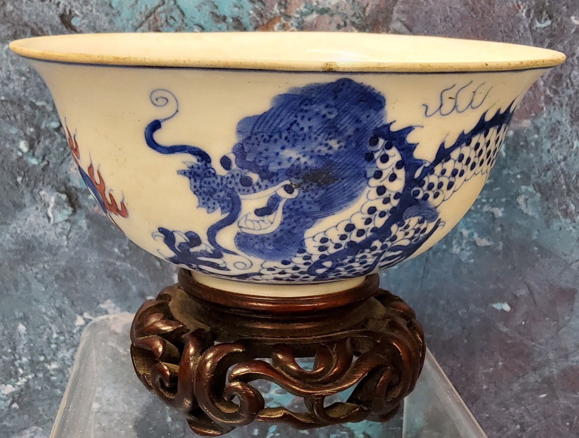 A 19th century Chinese bowl, the exterior in cobalt blue with the dragon chasing the flaming