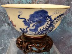 A 19th century Chinese bowl, the exterior in cobalt blue with the dragon chasing the flaming