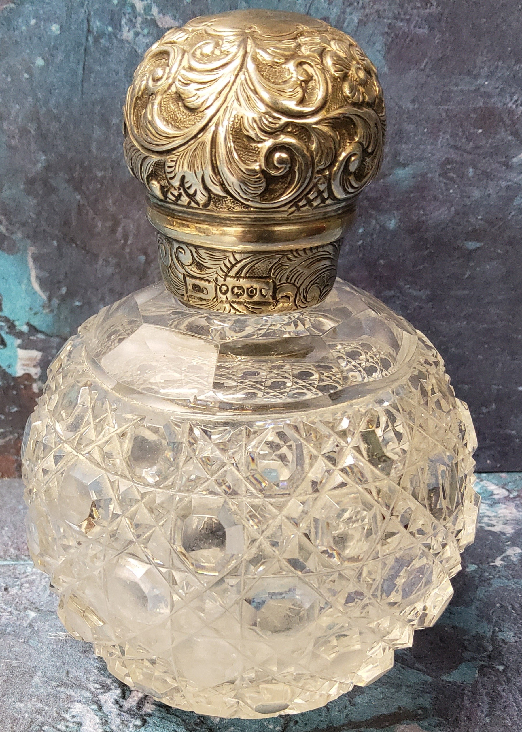A Victorian hobnail cut and silver globular scent flask, the cover embossed with scrolling
