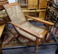 A late 19th/ early 20th century plantation chair, rattan seat, fold out leg rests c.1900