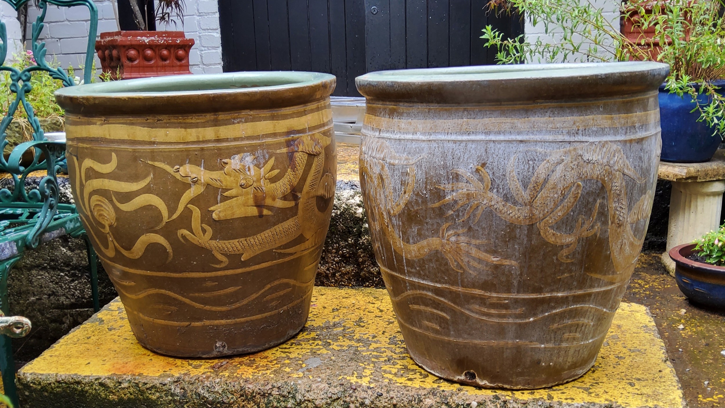 Two large Chinese planters decorated with a ferocious dragon chasing the pearl with Scripture