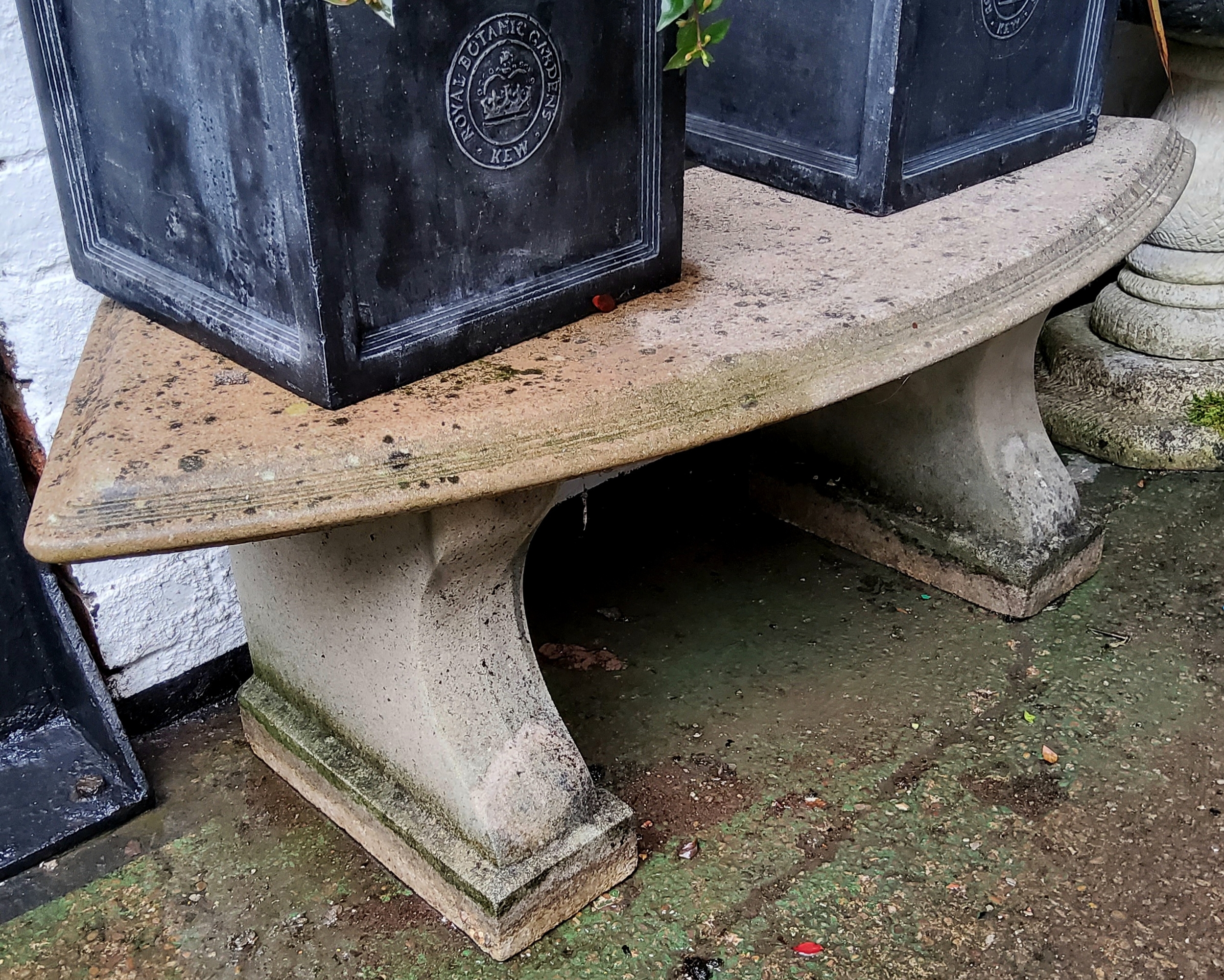 A reconstituted stone bowed garden seat