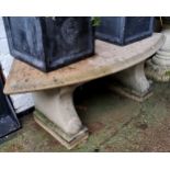 A reconstituted stone bowed garden seat