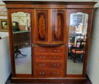 A good Edwardian Sheraton Revival satinwood inlaid triple wardrobe, of break-bow fronted form, the