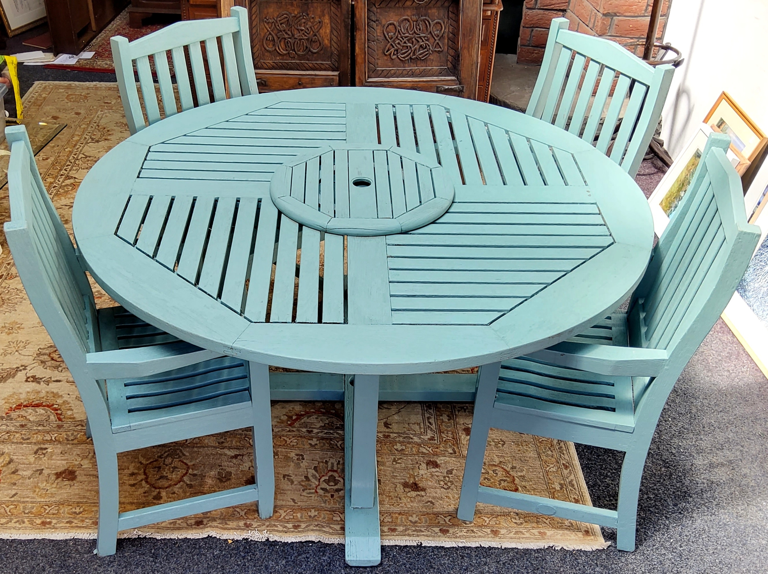 An English teak garden patio table and four armchairs, made by Lister, painted sage green, central