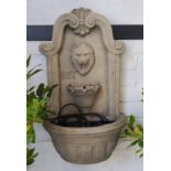 A reconstituted stone lion mask garden fountain