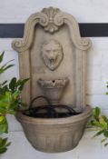 A reconstituted stone lion mask garden fountain
