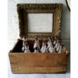 A 19th century frame, heavily distressed; a crate of early 20th century bottles