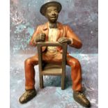 A cold painted bronze model, of a seated Mississippi Dandy, 18cm high