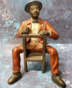 A cold painted bronze model, of a seated Mississippi Dandy, 18cm high