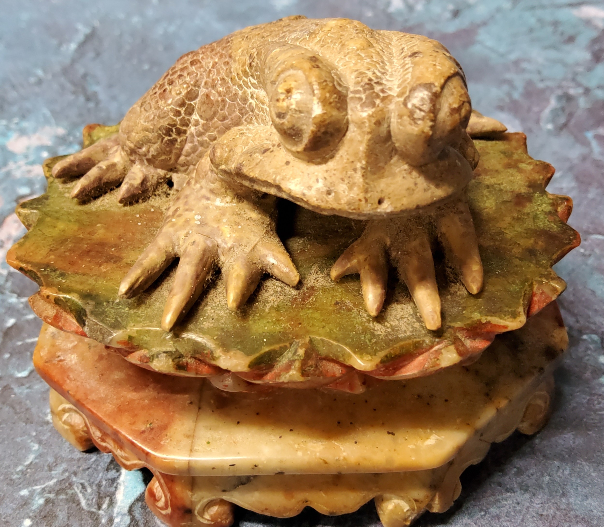 A 19th century Chinese soapstone model, of a toad, seated on a lotus, 5.5cm high