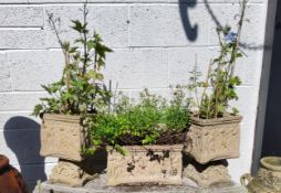 Three decorative reconstituted stone garden planters decorated in relief with putti
