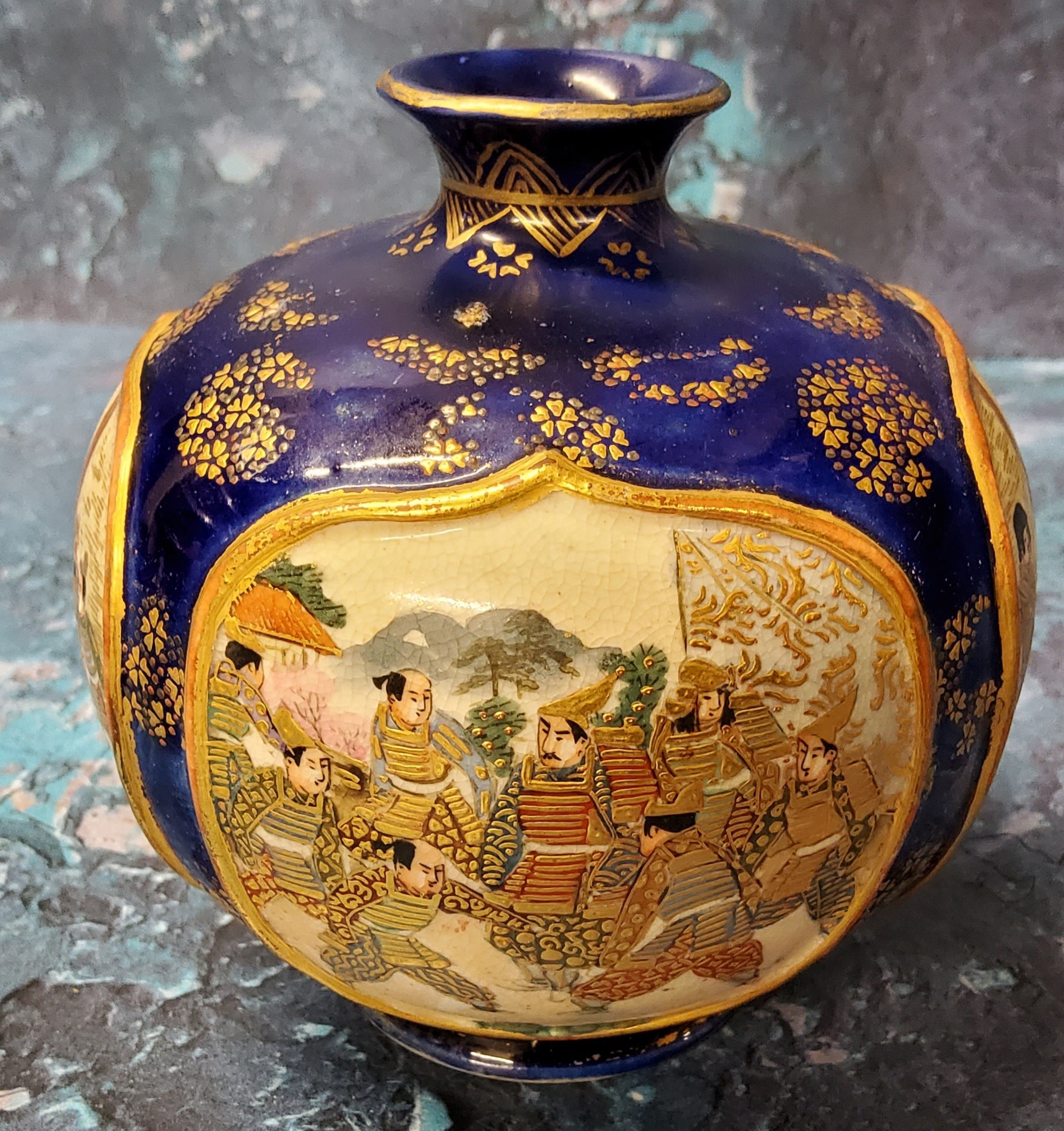 A Japanese Satsuma globular vase, with four raised cartouches, each with figures, cobalt blue ground