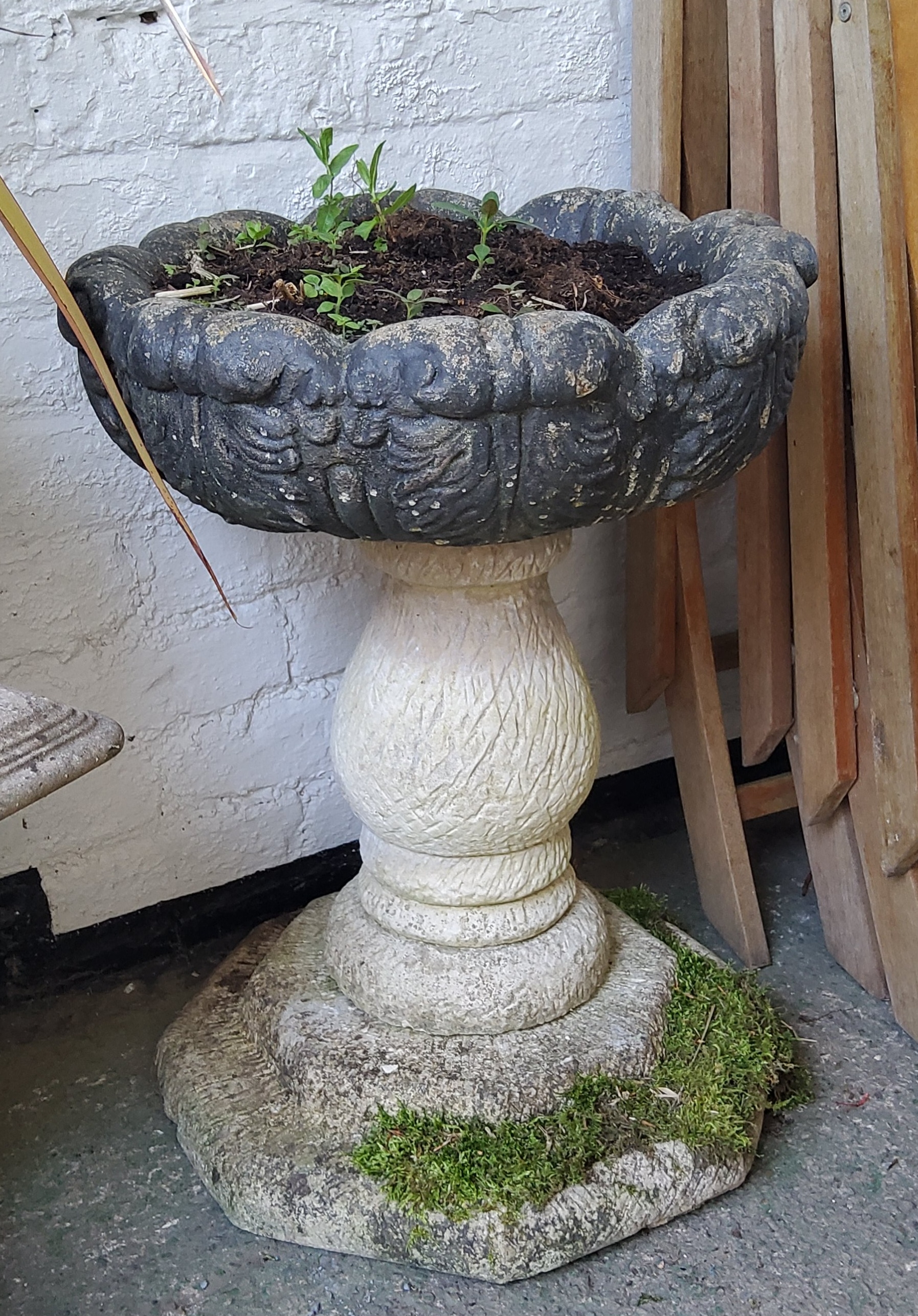 A reconstituted stone pedestal acanthus capped planter / urn