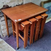 A mid 20th century teak nest of five occaisonal tables, the rectangular topped coffee table raised