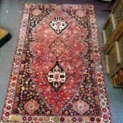 A late 19th / early 20th century hand woven Iranian Shiraz rug, three central geometrical guls and
