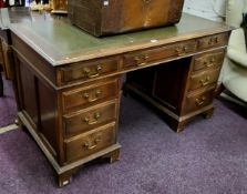 An early 20th century oak pedestal kneehole desk, tooled green leather inlaid writing surface on