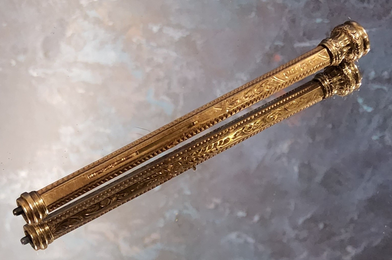 An early 20th century  9ct gold propelling pencil, engraved and chased with scrolling foliage,