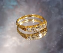 An early 20th-century gold and diamond five-stone carved half-hoop ring, the graduated old-cut