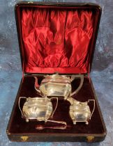 A late Victorian silver three piece canted tea service, reeded band with foliage to angles, ball