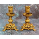 A pair of French gilt bronze candlesticks, the sconces cast with leaves, triform bases pieced and