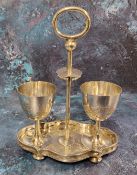 A Chinese silver double egg cup stand, posted loop handle, the shaped oval base engraved with