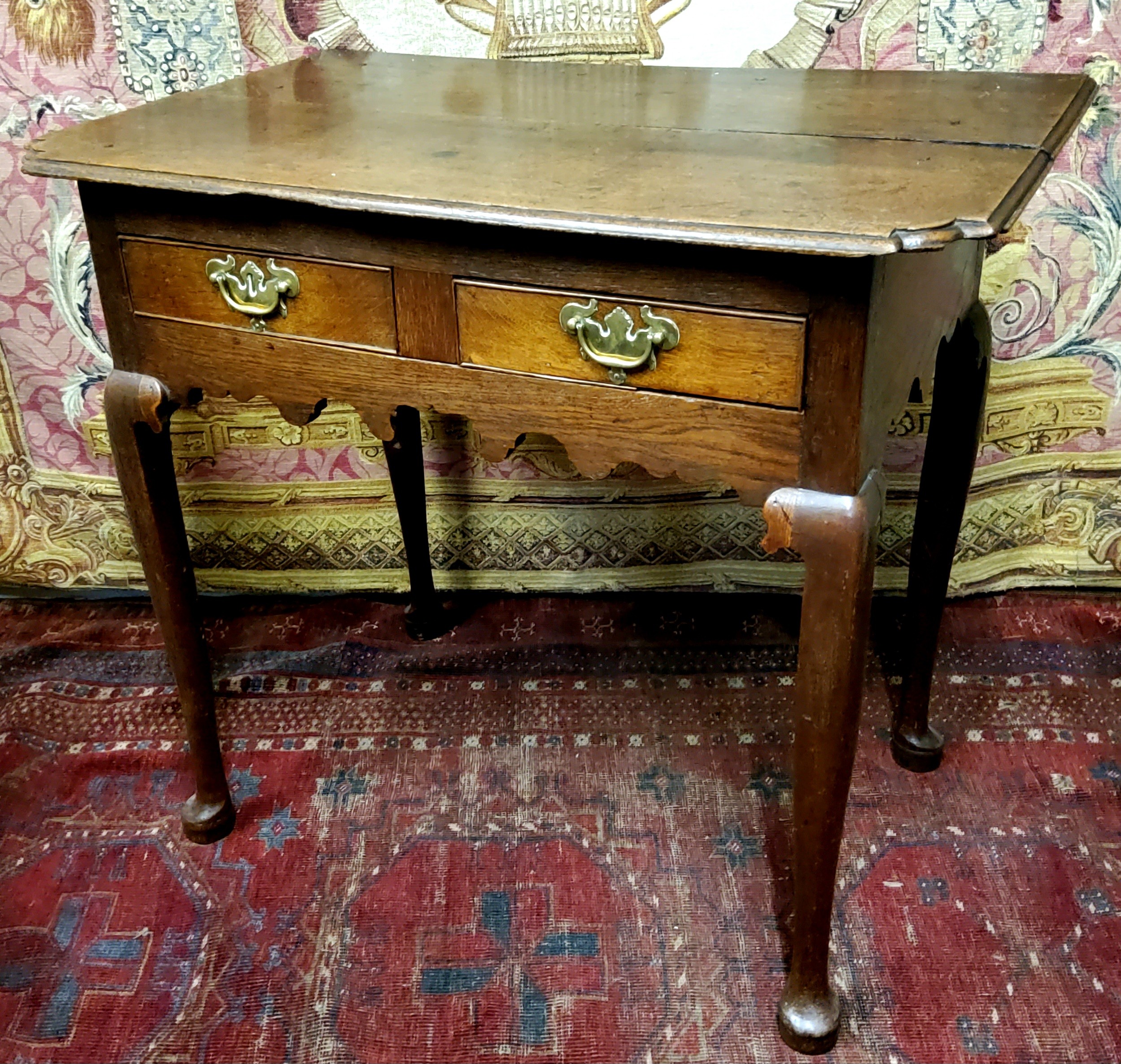 A George III oak lowboy or side table, oversailing shaped rectangular top with moulded edge above