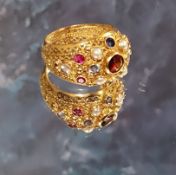 An 18ct gold Indian style cluster ring, collet set with rubies, sapphires & seed pearls, pierce work
